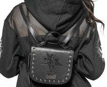 Load image into Gallery viewer, Black vegan leather backpack and crossbody bag. Features embossed bcc baphomet goat head on front with stud detail along front edges. Full zipper closure. Can be worn as a backpack, crossbody bag or can be carried with attached handle.
