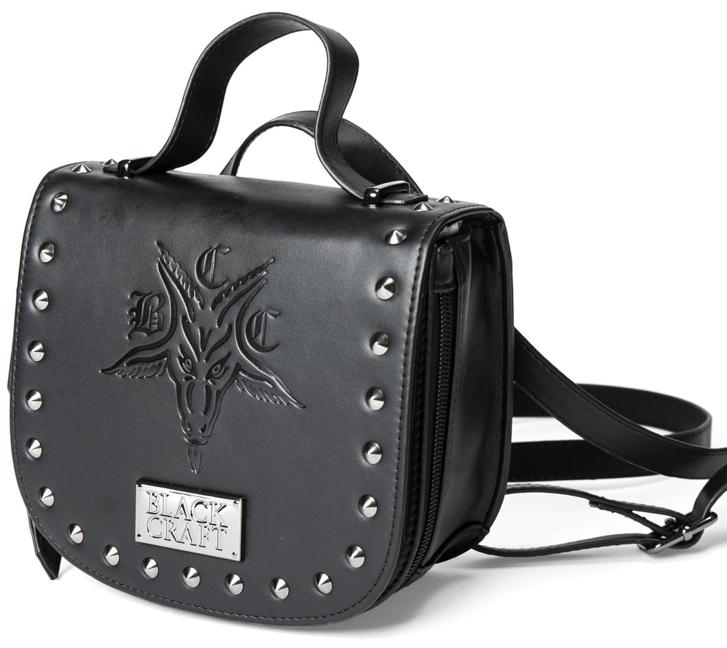 Black vegan leather backpack and crossbody bag. Features embossed bcc goat head on front with stud detail along front edges. Full zipper closure. Can be worn as a backpack, crossbody bag or can be carried with attached handle.